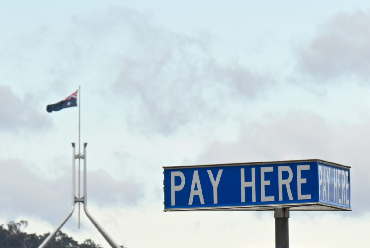 Australian Parliament House is seen behind a ‘Pay Here’ sign at a parking pay station in Canberra, Saturday, October 14, 2023. (AAP Image/Lukas Coch) NO ARCHIVING