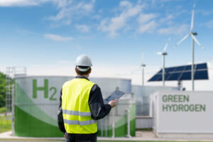 Engineer with tablet computer on a background of Green Hydrogen factory