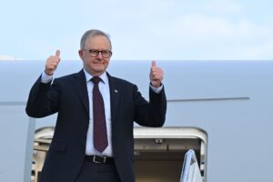 Australian Prime Minister Anthony Albanese gives a thumbs up as he boards a plane on departure at Joint Base Andrews in Maryland, United States, Tuesday, October 21, 2025.